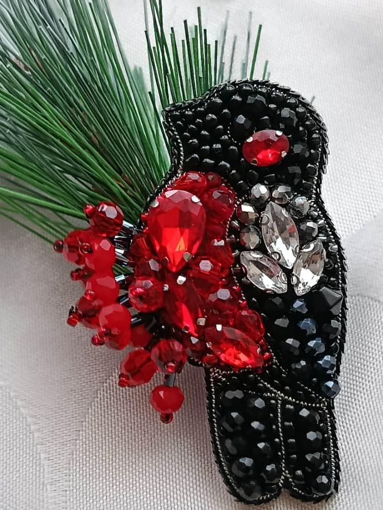 Broša Sarkankrūtītis uz zara