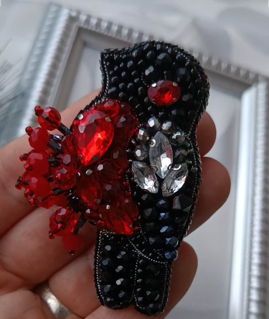 Broša Sarkankrūtītis uz zara