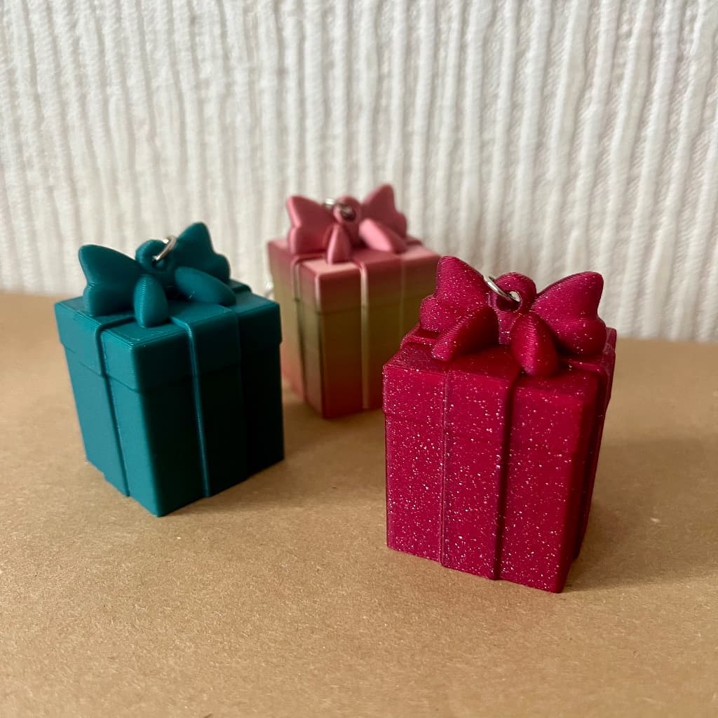 3D Printēts Piekariņš / Eglīšu Rotājums – Dāvanu Kastīte ar Kājiņām